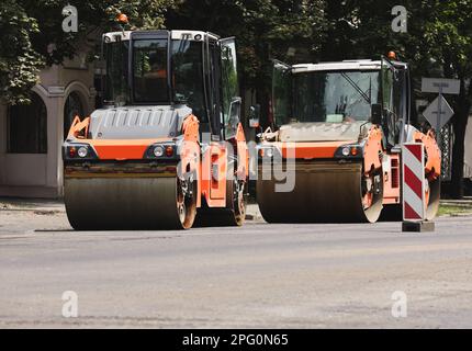 Des rouleaux modernes travaillent dans la rue de la ville. Réparation sur route Banque D'Images