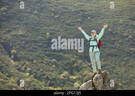 Tourisme avec sac à dos debout sur le pic dans les montagnes Banque D'Images