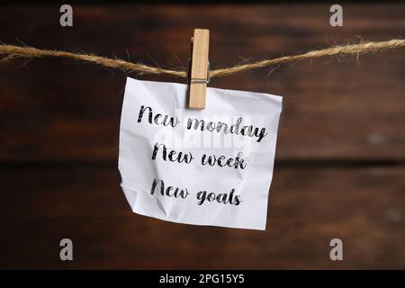 Nouveau lundi, nouvelle semaine, nouveaux objectifs - citation motivationnelle. Note en papier froissé avec texte sur fond en bois Banque D'Images