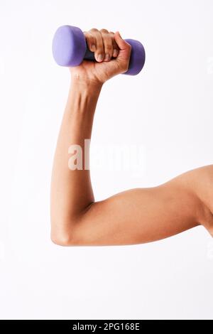 Ils sont très pratiques. Photo en studio d'une femme musclée qui s'efforce d'utiliser des haltères. Banque D'Images