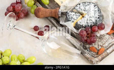 Vin rose et rouge servi avec des fromages, des noix, des raisins et des verres de vin. Délicieux repas vins divers en-cas servis à bord. Poser à plat sur une ba légère Banque D'Images