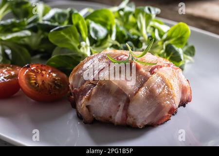 Camambert et bacon roulés jusqu'à ce qu'ils soient croustillants et servis avec de la salade verte et des tomates cerises Banque D'Images