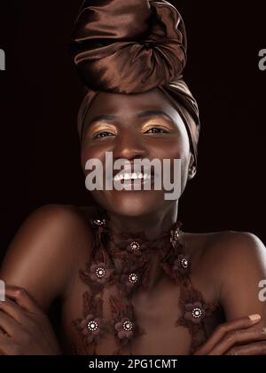 Tombez amoureux de la fabuleuse reine que vous êtes. Photo en studio d'une jeune femme attrayante posant dans une tenue africaine traditionnelle sur un fond noir Banque D'Images