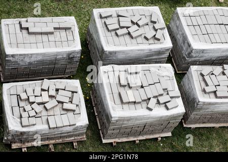 Pavés, carreaux empilés sur des palettes. Pavés sur le chantier, matériaux pour la restauration de la surface de la route. Vue de dessus Banque D'Images