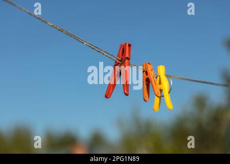 Épingles à linge colorées sur les cintres. Épingles à linge en plastique de différentes couleurs. Banque D'Images