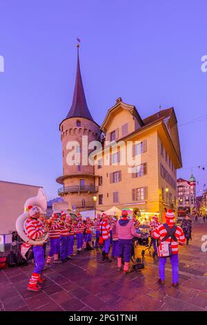 Lucerne, Suisse - 20 février 2023: Groupe de musiciens en costumes et en foule, au lever du soleil, partie du Carnaval de Fasnacht, à Lucerne (Lucerne), SWI Banque D'Images