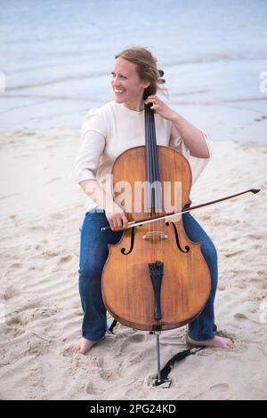 Femme violoncelle sur la plage Banque D'Images