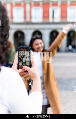 amis asiatiques et latins visitant la ville et prenant des photos les uns des autres Banque D'Images