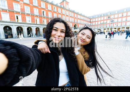 Photo de vos amis heureux en train de prendre des photos avec un téléphone en visite dans la ville Banque D'Images