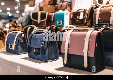 Collection de sacs à main élégants pour femmes de différentes couleurs avec bretelles sur un support dans un magasin Banque D'Images