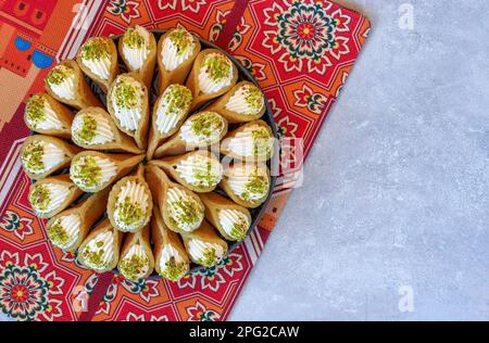 Crêpe arabe Qatayef avec crème qishta et pistache . Bonbons traditionnels du ramadan . Vue de dessus, espace de copie Banque D'Images