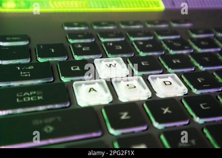 Touches de jeu surlignées avec voyant vert et violet. Gros plan sur un clavier noir puissant pour ordinateur portable. Technologie, INFORMATIQUE, e-sport, informatique Banque D'Images
