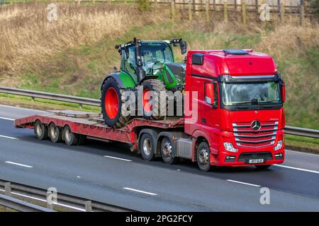 2017 Red MERCEDES BENZ 2551LS 12809cc Diesel ACTROS camion transportant un tracteur FENDT T20 sur chargeur bas ; se déplaçant sur l'autoroute M6, Royaume-Uni Banque D'Images