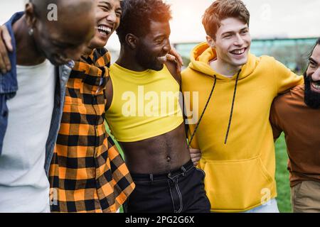 Jeunes hommes divers s'embrassant les uns les autres au parc de la ville - concentrez-vous sur le visage de gars portant le chandail jaune Banque D'Images