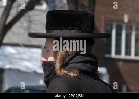 Un juif hassidique orthodoxe avec un long peyot à boucles, un chapeau noir et un foulard couvrant sa bouche. À Brooklyn, New York, par une froide journée d'hiver Banque D'Images