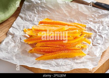 Des peaux d'orange confites sur du papier de cuisson froissé Banque D'Images