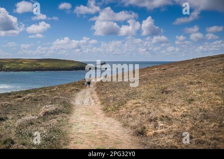 Une mère et un tout-petit marchant main le long d'un sentier accidenté sur Pentire point East sur la côte à Newquay, en Cornouailles, au Royaume-Uni. Banque D'Images