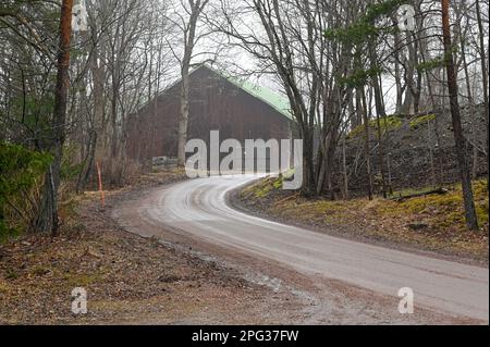 route de gravier à côté de la vieille grange un jour brumeux Banque D'Images