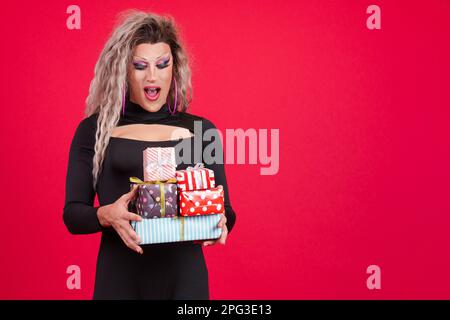 Surprise transgenre personne avec le maquillage tenant beaucoup de cadeaux Banque D'Images
