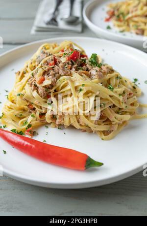 Pâtes au thon, à l'ail, au Chili, à l'huile d'olive et au persil. Cuisine italienne traditionnelle nouilles aglio e olio sur l'assiette Banque D'Images