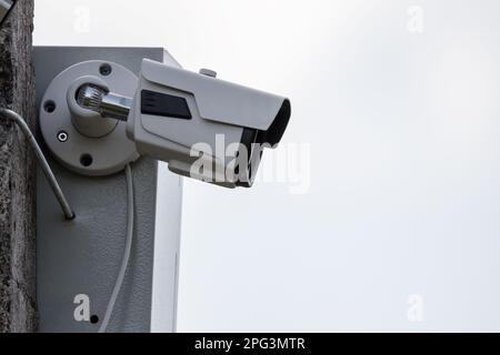 L'observation CCTV est en cours. La caméra de télévision en circuit fermé est montée sur un poteau de rue en béton sous un ciel lumineux Banque D'Images