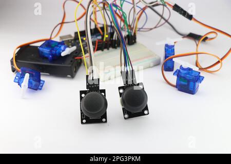 Les modules de joystick contrôlent le circuit de micro servos réalisé sur une carte d'expérimentation avec des fils volants. Électronique utilisée dans l'ingénierie de produits de bricolage Banque D'Images