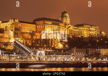 Budapest, Hongrie vue de nuit illuminée sur le château de Buda site palatial, vue depuis les rives du Danube. Banque D'Images