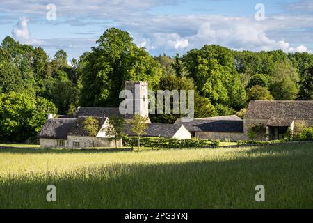 Le soleil brille sur la tour de l'église traditionnelle du village de St Andrew à Coln Rogers dans les Cotswolds d'Angleterre. Banque D'Images