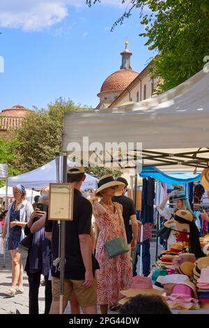 Femme essayant un chapeau, Mercato di Santo Spirito, Florence, Italie Banque D'Images