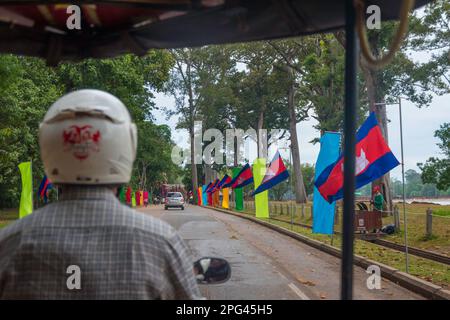 Tuktuk Tuk conducteur de Tuk dans un casque vu de derrière lorsqu'il conduit dans une rue à Siem Reap au Cambodge. Banque D'Images