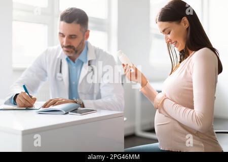 Grossesse et concept de médicament. Médecin prescrivant des pilules pour la jeune femme enceinte pendant le rendez-vous au bureau Banque D'Images