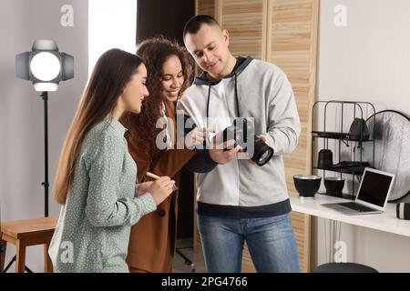 Photographe professionnel et maquilleur avec modèle en studio Banque D'Images