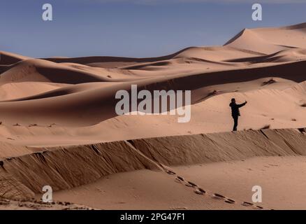 Un touriste chinois prend un "selfie" dans les dunes de sable du Sahara à Merzouga. Banque D'Images