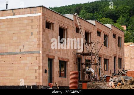 Petit chantier de construction, mur en briques orange, petit échafaudage à proximité Banque D'Images