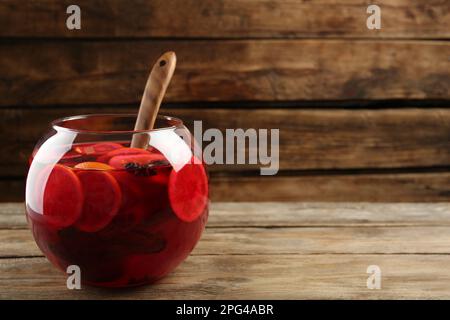 Bol en verre de délicieux punch aromatique et louche sur une table en bois. Espace pour le texte Banque D'Images