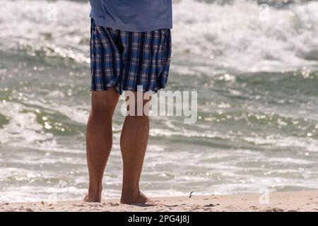 Un homme se tient au bord de l'eau sur la plage de Perdido Key en Floride sur 16 mars 2023. Banque D'Images