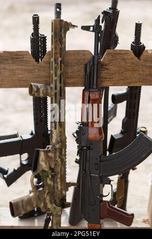 Fusil d'assaut américain moderne 5,56mm et Kalashnikov 5,45mm sur un stand d'armes à l'extérieur du stand de tir Banque D'Images