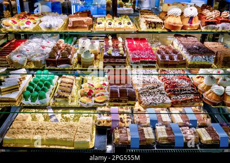 Vitrine avec quatre étagères pleines de divers gâteaux savoureux et magnifiquement colorés Banque D'Images