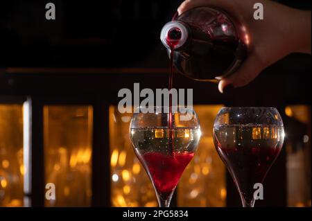 Boisson de Kir Royal, cocktail apéritif français à base de crème de cassis recouverte de champagne, servi dans des verres de tulipe servis au bar Banque D'Images