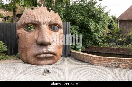 Le masque de visage ou l'art de cloison créé par Rick Kirby , sculpteur britannique assis à l'extérieur du théâtre Marlowe à la ville de Canterbury, Kent Royaume-Uni. Banque D'Images