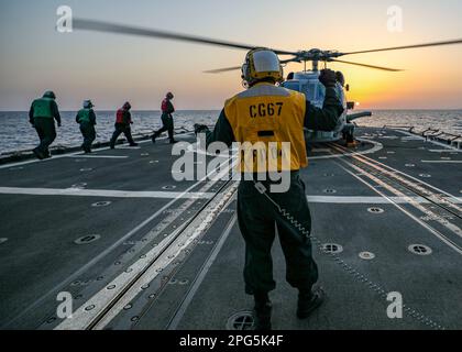 MER DES PHILIPPINES (11 mars 2023) un hélicoptère MH-60R Sea Hawk, affecté aux « seigneurs de guerre » de HSM-51, dévole du pont de vol du croiseur à missiles guidés de classe Ticonderoga USS Shiloh (CG 67) dans la mer des Philippines, au 11 mars. Shiloh est affecté au Commandant de la Force opérationnelle (CTF) 70 et est déployé à Yokosuka, au Japon, pour soutenir la sécurité des États-Unis et de leurs alliés dans l'Indo-Pacifique. (É.-U. Photo de la marine par le spécialiste des communications de masse 2nd classe Arthur Rosen) Banque D'Images