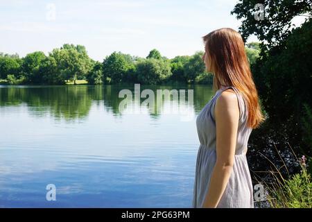 jeune femme regardant un lac idyllique avec un espace de copie Banque D'Images