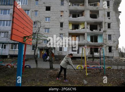 Borodyanka, Ukraine. 20th mars 2023. Une femme enlève les feuilles sèches d'un terrain de jeu près d'un bâtiment résidentiel endommagé par des bombardements par l'armée russe dans la ville de Borodyanka, région de Kiev. Crédit : SOPA Images Limited/Alamy Live News Banque D'Images