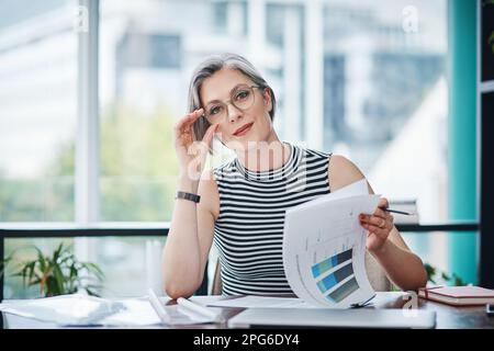 J'ai travaillé dur et ça se voit dans les chiffres. d'une femme d'affaires mûre travaillant sur la paperasse dans son bureau. Banque D'Images