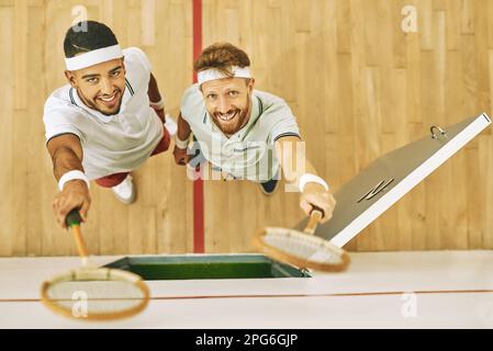 C'est un rire une minute dans ce club de squash. Portrait d'un jeune homme  heureux tenant sa raquette de courge dans le vestiaire Photo Stock - Alamy