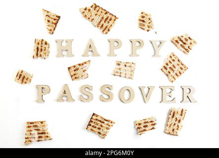 Pesach célébration concept - vacances juives Pesach. Matzah carré brisé en morceaux isolés sur fond blanc. Lettrage « Happy Passover » Banque D'Images