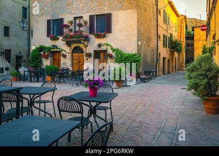 Charmant café de rue avec des tables et des chaises dans l'ancienne rue pavée tôt le matin, Pienza, Toscane, Italie, Europe Banque D'Images