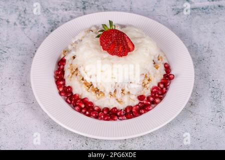 Dessert Gullac. Dessert traditionnel du Ramadan. Dessert Gullac avec grenade et fraise sur l'assiette Banque D'Images