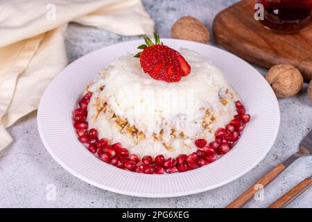 Dessert Gullac. Dessert traditionnel du Ramadan. Dessert Gullac avec grenade et fraise sur l'assiette Banque D'Images