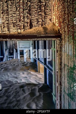 Du sable soufflé dans le désert du Namib remplir les chambres d'une maison dans la ville fantôme d'exploitation des diamants de Kolmanskop près de Lüderitz en Namibie. Banque D'Images